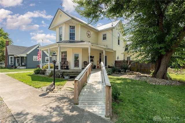 view of front of house with covered porch and a front lawn