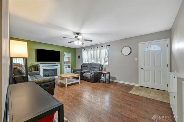 living room with dark wood-type flooring and ceiling fan