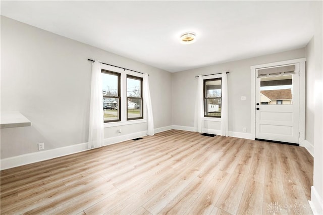 empty room with light hardwood / wood-style flooring