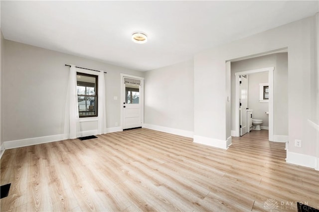 interior space with light wood-style flooring, visible vents, and baseboards