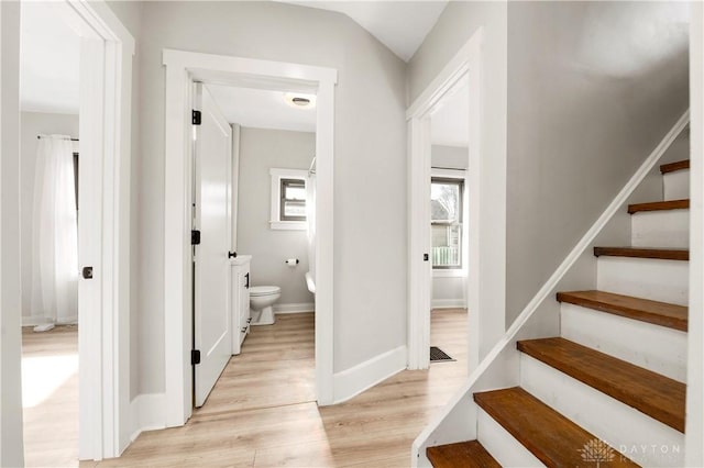 hallway featuring lofted ceiling and light hardwood / wood-style flooring