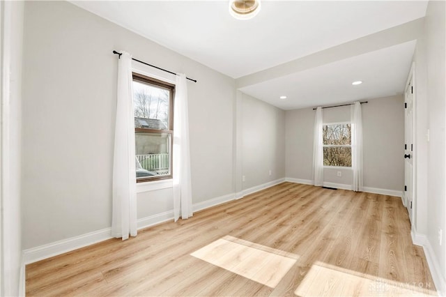 spare room with light wood finished floors, baseboards, and recessed lighting