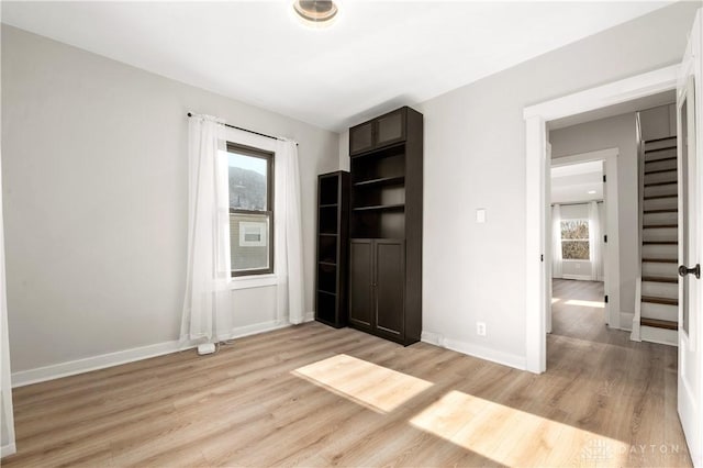 unfurnished bedroom with baseboards and light wood-style floors