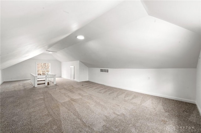 bonus room with visible vents, vaulted ceiling, light carpet, and baseboards