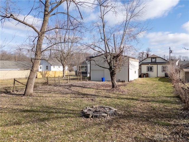 view of yard featuring an outdoor fire pit and a garage