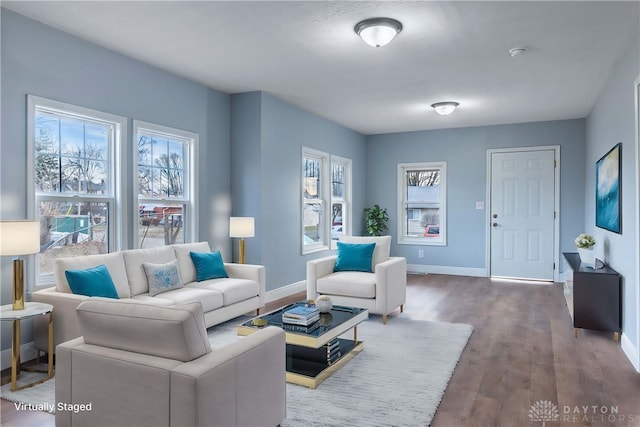 living area with baseboards and wood finished floors