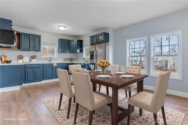 dining room with sink and light hardwood / wood-style flooring