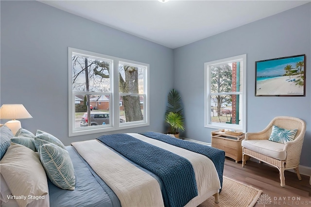 bedroom with multiple windows and hardwood / wood-style flooring