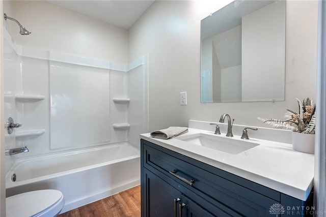 full bathroom with vanity, hardwood / wood-style floors, tub / shower combination, and toilet