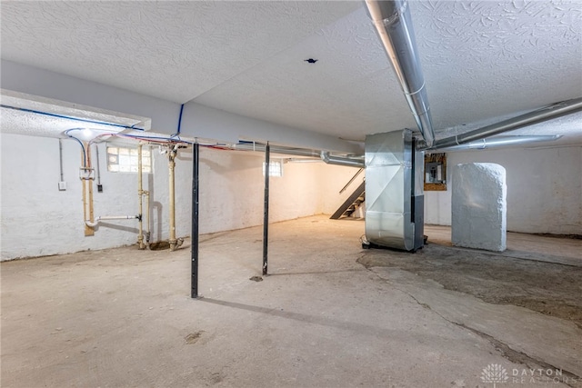 basement with heating unit and a textured ceiling