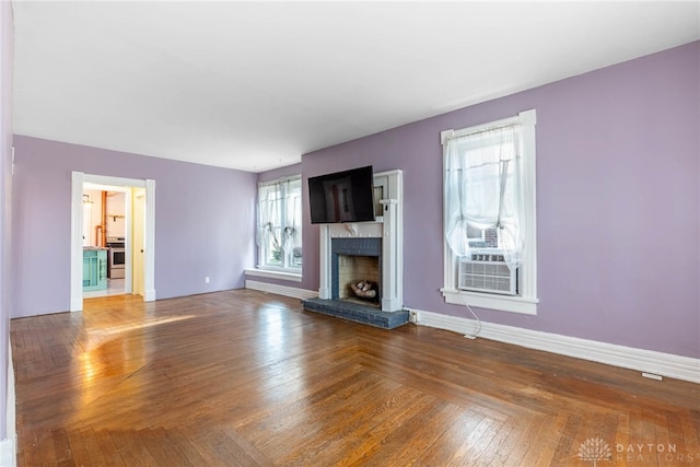 unfurnished living room with hardwood / wood-style floors, a fireplace, and cooling unit