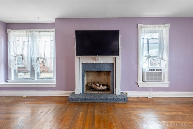 unfurnished living room with cooling unit, parquet floors, and a fireplace