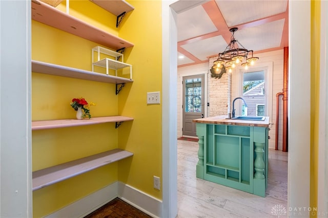 interior space with a sink, baseboards, and wood finished floors