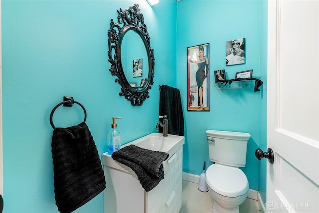 bathroom featuring baseboards, toilet, and vanity