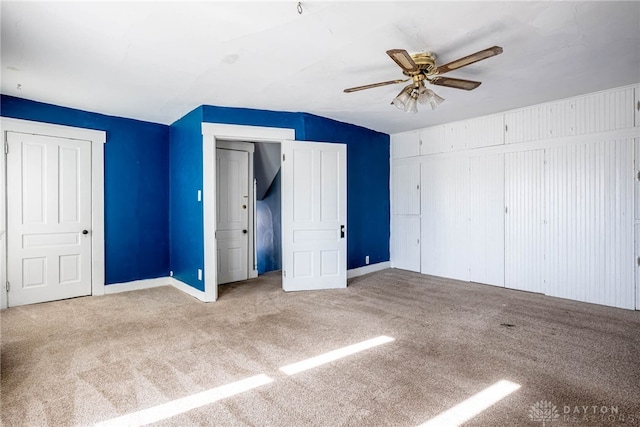 unfurnished bedroom featuring ceiling fan and carpet