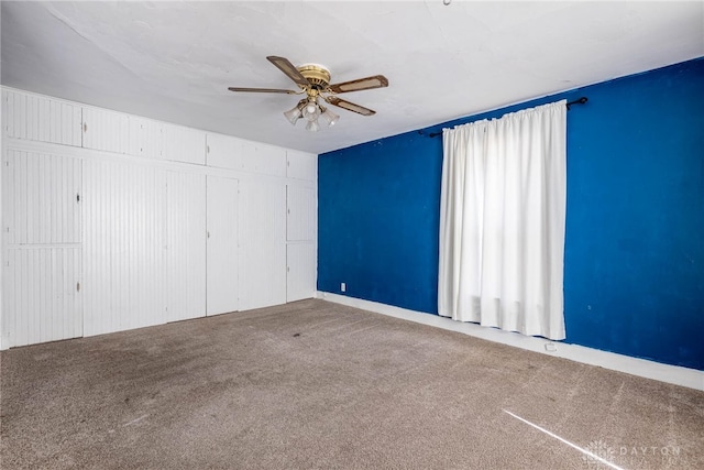 carpeted spare room featuring ceiling fan