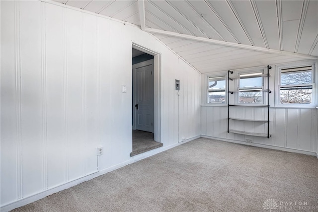 carpeted empty room with vaulted ceiling