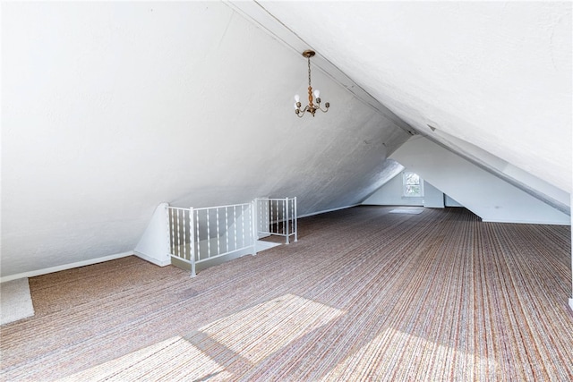 additional living space with vaulted ceiling, carpet flooring, and an inviting chandelier