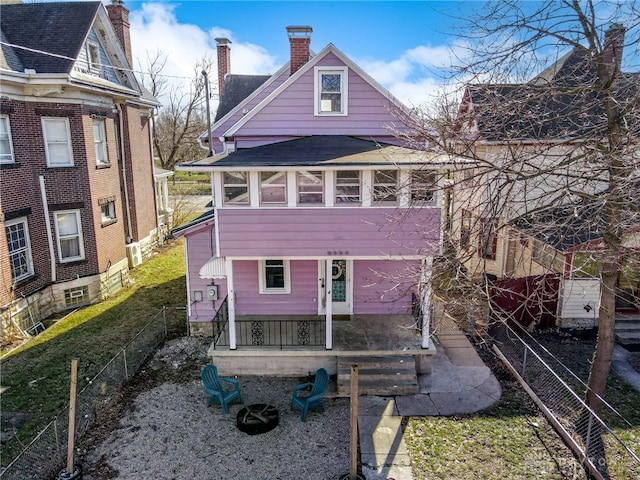 back of property featuring roof with shingles, a chimney, and fence