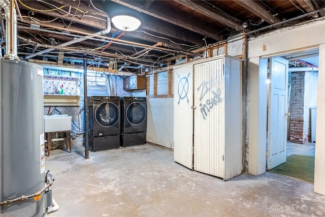 basement featuring gas water heater, sink, and washing machine and dryer