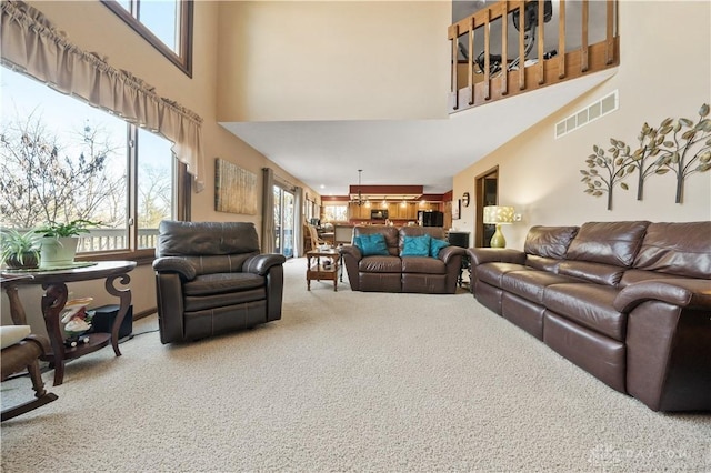 carpeted living room with a high ceiling