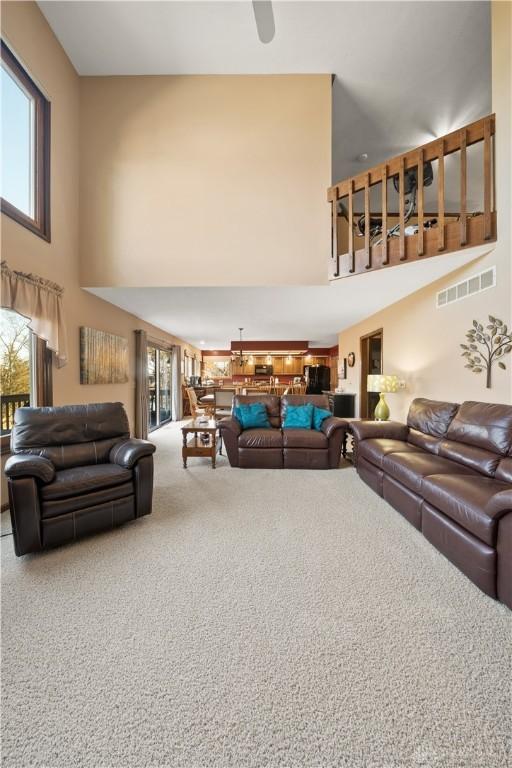 carpeted living room with a high ceiling