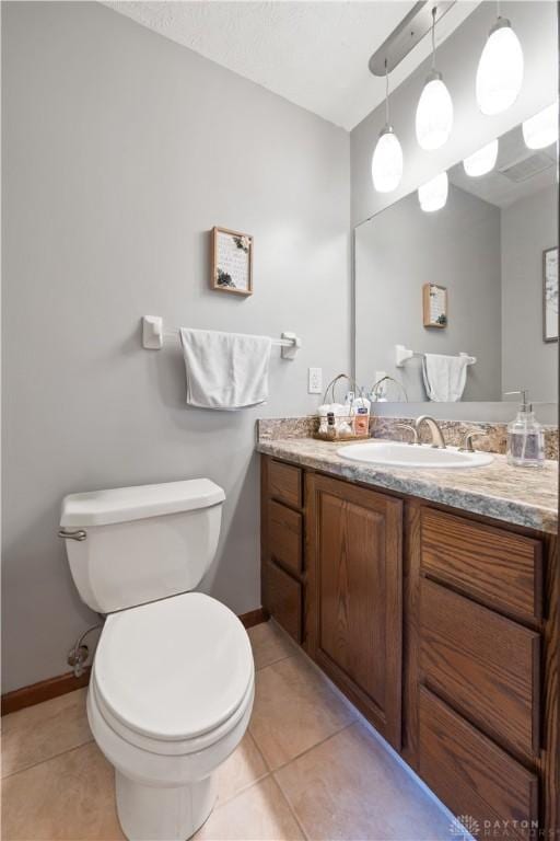 bathroom with vanity, tile patterned flooring, and toilet