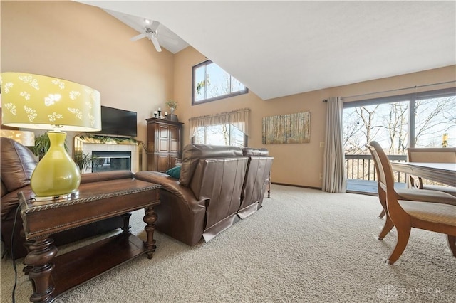 living room featuring a fireplace, carpet floors, high vaulted ceiling, and ceiling fan