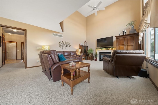 carpeted living room featuring ceiling fan and high vaulted ceiling