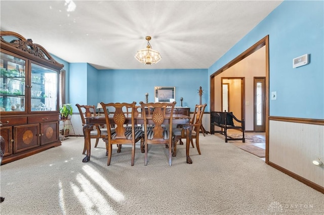 carpeted dining area featuring a chandelier