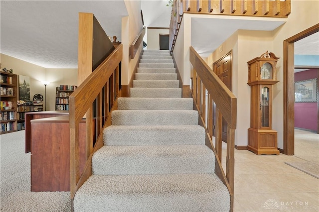 stairs featuring tile patterned flooring and a textured ceiling