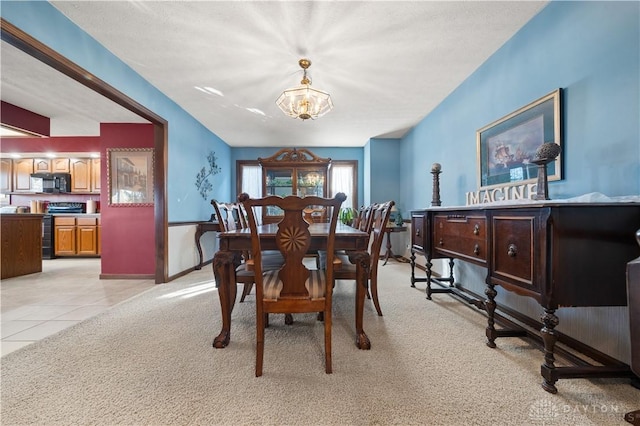 dining space with light tile patterned floors and a chandelier