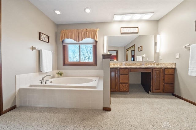 bathroom featuring tiled tub and vanity