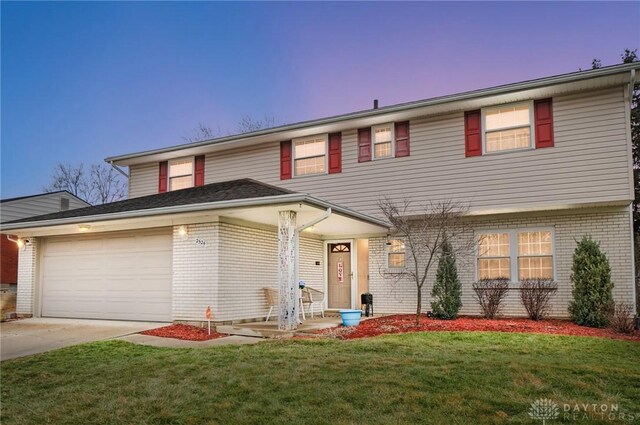 view of front of home featuring a garage and a lawn