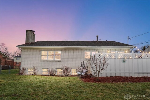 property exterior at dusk featuring a yard