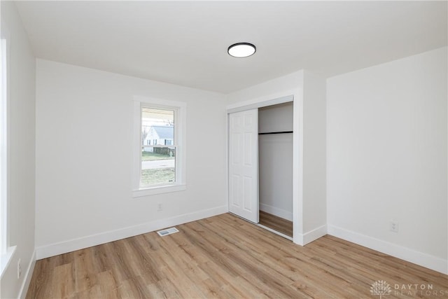 unfurnished bedroom featuring a closet and light hardwood / wood-style flooring