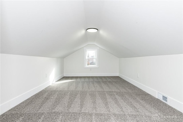 bonus room with carpet floors and vaulted ceiling