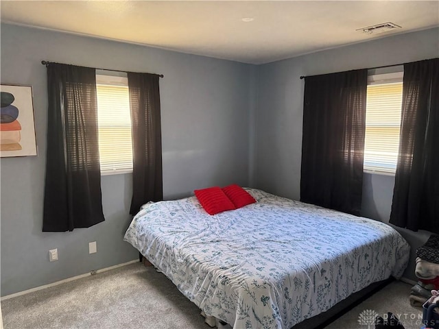 carpeted bedroom with baseboards and visible vents