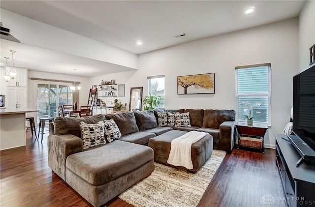 living room featuring a notable chandelier and dark hardwood / wood-style floors