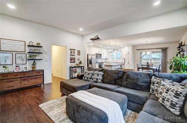 living room featuring dark wood-type flooring and an inviting chandelier