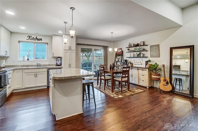 kitchen with hanging light fixtures, white cabinetry, and a center island