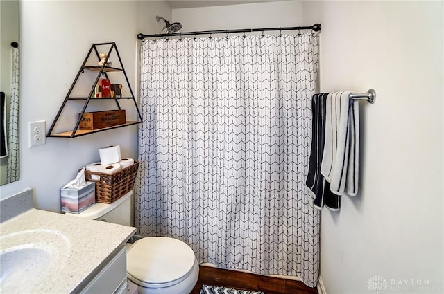 bathroom featuring vanity, toilet, and walk in shower