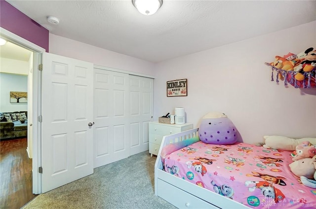 carpeted bedroom with a closet and a textured ceiling