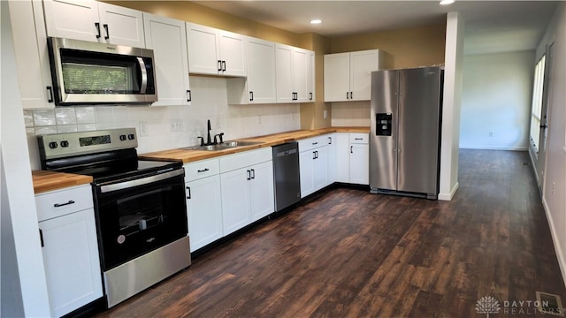 kitchen featuring appliances with stainless steel finishes, butcher block counters, and white cabinets