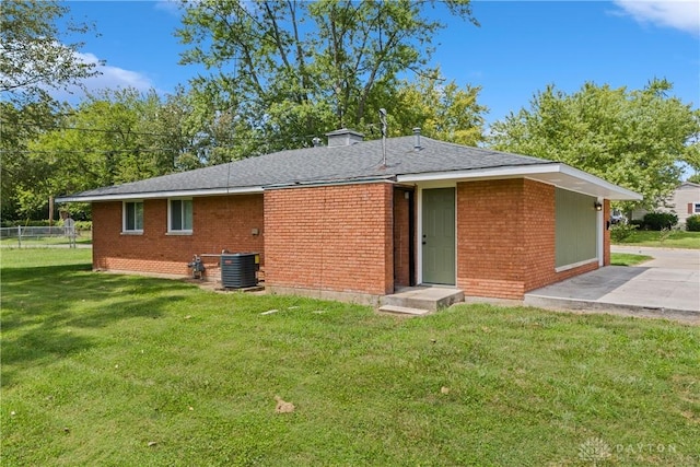 rear view of house featuring a patio, a yard, and central air condition unit