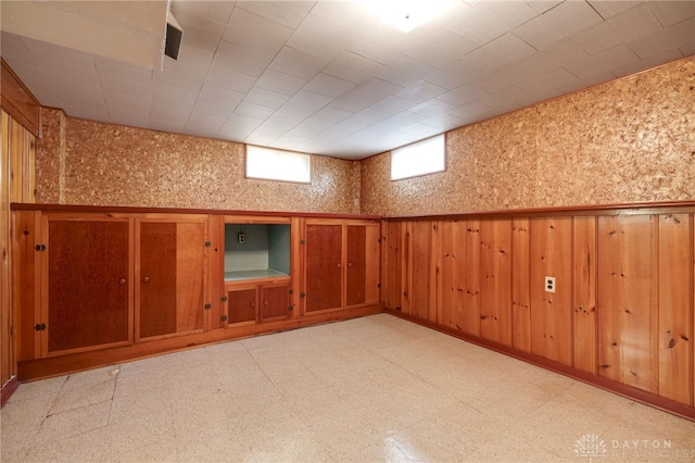 basement featuring wooden walls