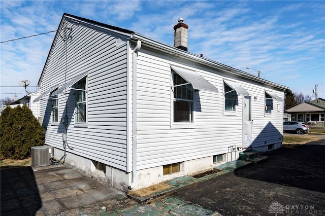 view of side of home with central AC unit