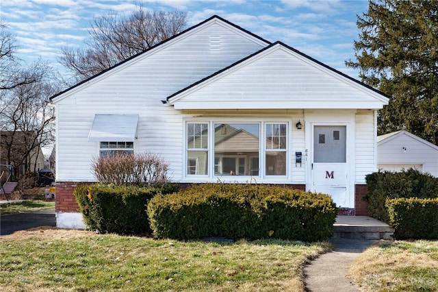 bungalow-style house featuring a front lawn