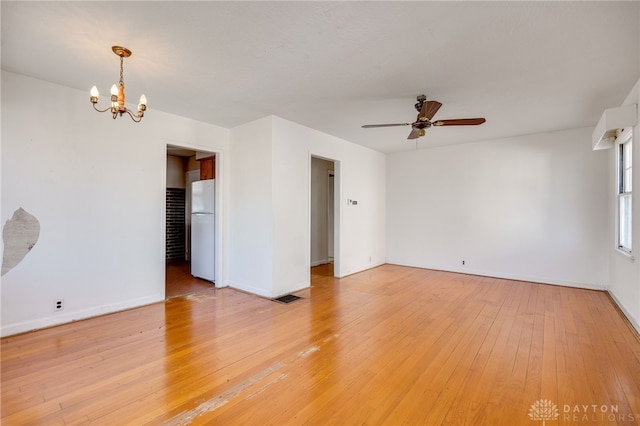 empty room featuring hardwood / wood-style flooring and ceiling fan with notable chandelier