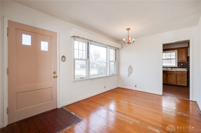 entryway featuring a chandelier, sink, and light hardwood / wood-style flooring